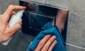 foto di due mani intente a sanificare interruttori